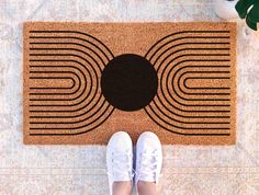 a person standing in front of a door mat on the floor with their feet up