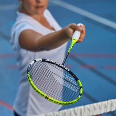 a woman holding a tennis racquet on top of a tennis ball racket