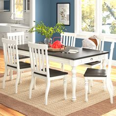 a dining room table and chairs with blue walls