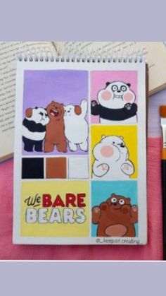 an open notebook with pictures of bears and pandas on it, next to paintbrushes