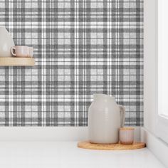 a white and gray plaid wallpaper in a room with two vases on the shelf