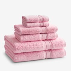 six pink towels stacked on top of each other in front of a white background,