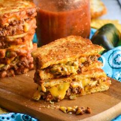 two grilled cheese sandwiches stacked on top of each other next to a jar of ketchup