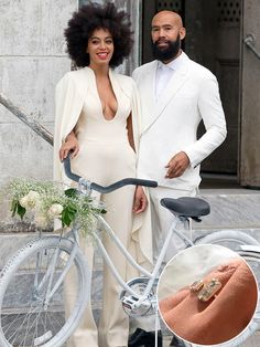 a man and woman standing next to a bicycle