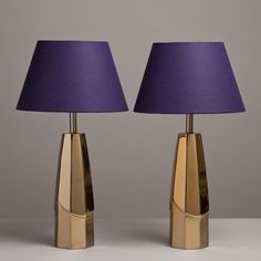 two gold and purple lamps sitting next to each other