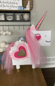 a pink and white pony with a heart on it's back sitting on a table