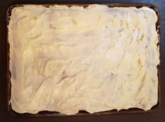 a pan filled with white frosting sitting on top of a counter