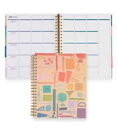 a planner book with colorful stickers on the cover and a spiral - bound notebook