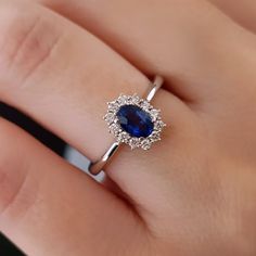 a woman's hand with a diamond and blue sapphire ring