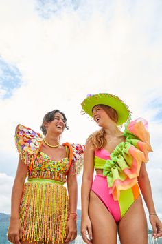 two women in colorful bathing suits standing next to each other