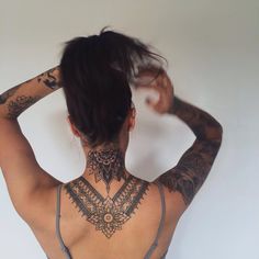 a woman with tattoos on her back and neck