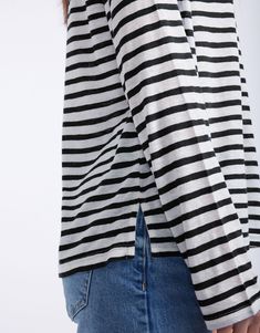 DESCRIPTION Embrace casual comfort with the Long Weekend Top in White/Black Stripe by White & Co. This top is designed for comfort and style, featuring a relaxed fit, crew neckline, and long sleeves. The crisp white base with black stripes brings a classic look perfect for casual days. This top ensures all-day comfort, making it an ideal choice for weekend wear or a relaxed day out. Team the Long Weekend Top with rolled-up jeans and white sneakers for a casual yet chic look. This versatile top s Jeans And White Sneakers, Rolled Up Jeans, Weekend Wear, Long Weekend, White Sneakers, Black Stripes, Long Tops, Stripes Pattern, Classic Looks