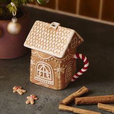 a gingerbread house is next to some cinnamon sticks