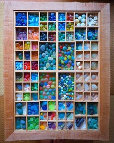 a wooden box filled with lots of different colored rocks