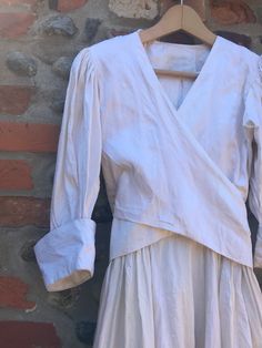 a white dress hanging on a brick wall