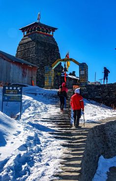 two people walking up some steps in the snow