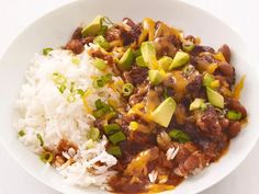 a white bowl filled with rice, beans and avocado on top of it