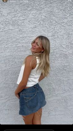 a woman standing in front of a white wall