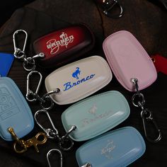 several keychains with various logos on them sitting next to each other