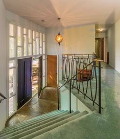 the stairs lead up to an entryway with glass doors and railings on both sides