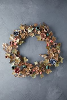 a wreath made out of flowers and leaves on a gray background with the letter c