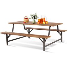 a picnic table with two benches next to each other and fruit on the table top