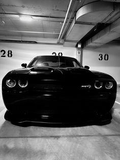 a black and white photo of a car parked in a parking garage with the number 30 on it