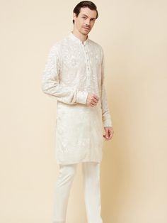 This Lucknowi kurta will instantly give an elegant look. Made from polyester cotton fabric, this 2 piece kurta set features a white lucknowi kurta, front buttons fastening, designer cuff buttons, and a mandarin collar. This lucknowi kurta has beautiful chikankari embroidery work all over. It is paired with white churidar pants. An ideal outfit for traditional & special events.

Size Chart For Men





	
	
					Men's Size Chart
		

		
		
						
				Size Chart For Men
				Custom Size Measurement G Off White Kurta For Eid Festivities, Off White Kurta For Festive Eid Celebrations, Festive Off White Kurta For Eid, Off-white Kurta For Festive Eid Celebrations, Eid Festive Off White Kurta, Off White Naqshi Kurta For Diwali, White Bollywood Style Cotton Nehru Jacket, Formal Off White Kurta For Diwali, White Bollywood Style Nehru Jacket