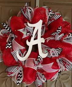 a wreath that has the letter a on it and is decorated with red, white and black mesh