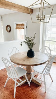 a dining room table with white chairs around it