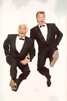 two men in tuxedos jumping up into the air with their mouths wide open