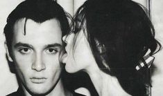 a black and white photo of a man kissing a woman's head with her eyes closed