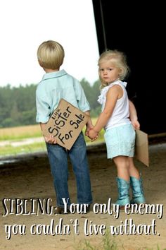 two young children holding hands and standing in front of a barn