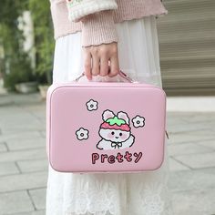 a woman holding a pink hello kitty lunch box with the word pretty written on it