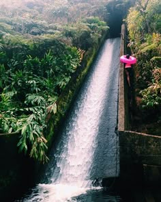 someone is standing at the top of a waterfall