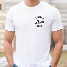 The Football Dads Club tee is a classic jersey short sleeve t-shirt that fits like a well-loved favorite. Perfect for active and leisure this t-shirt makes a great game day football shirt for dad or football season shirt for dads with kids playing football. Soft cotton and quality print make you fall in love with it over and over again. .: Crew neckline .: Made with 100% Airlume combed and ring-spun cotton .: Lightweight fabric that is breathable and easy to layer .: Sustainable manufacturing .: Ribbed knit collar with seam .: The tear-away label minimizes skin irritations ---------------------- SHIPPING INFO ---------------------- Please allow 1-3 days to print and process your order. From there shipping time for your order is approximately 2-5 business days. Once shipped you'll receive t Father's Day Team Spirit Graphic T-shirt, Cotton Tops For Father's Day Sports Events, Cotton Tops For Sports Events On Father's Day, Father's Day Fan Apparel T-shirt With Team Name, Sporty Crew Neck T-shirt For Father's Day, Father's Day White Pre-shrunk Top, Father's Day Team Spirit T-shirt With Crew Neck, Father's Day Team Spirit Crew Neck T-shirt, Father's Day Team Spirit Tops With Graphic Print