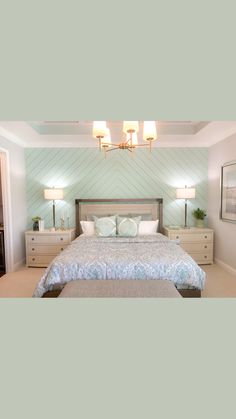 a bedroom with a bed, dressers and two lamps on either side of the bed