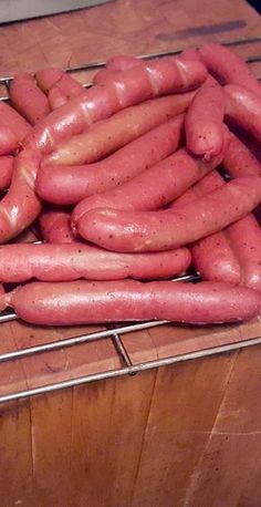 a bunch of hot dogs sitting on top of a metal rack