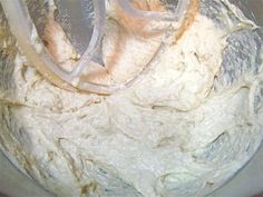 a mixing bowl filled with batter and white icing, ready to be mixed in