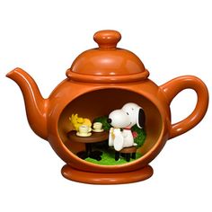 a teapot shaped like a dog with a table and two dogs in the bowl