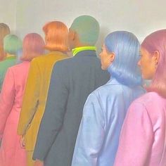 a group of people standing next to each other in front of a wall with colored hair