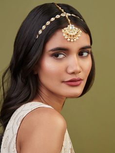 a woman wearing a gold head piece