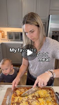 a woman and child are in the kitchen preparing food on a cutting board with a knife