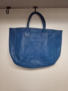 D67 There are minor stains.Please look carefully at the photos, as they are considered to be part of the description. This Ann Taylor tote bag is a stylish accessory for any casual or workwear outfit. The bag features a pebbled texture pattern and is made of high-quality leather in a beautiful sapphire blue color. The bag has an open closure and a large size, measuring 17 inches in width and 12 inches in height.  The bag's handles are made of matching leather in a blue color, adding a pop of contrast to the white contrast stitching throughout the bag. The tote bag has a modern and high-fashion style, with accents that make it stand out from the rest. This bag is perfect for anyone looking for a large, versatile bag that can be used for any occasion. Classic Blue Pouch Bag, Rectangular Shoulder Bag With Pebbled Texture For Travel, Rectangular Bags With Pebbled Texture For Daily Use, Rectangular Pebbled Texture Shoulder Bag For Travel, Chic Bags With Pebbled Texture For Daily Use, Leather Satchel Shoulder Bag With Pebbled Texture, Leather Bag With Pebbled Texture, Rectangular Shape, Leather Bag With Pebbled Texture And Rectangular Shape, Rectangular Shoulder Bag With Pebbled Texture