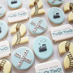 cookies decorated with train tracks and cars are displayed on a white tablecloth that says rail road two