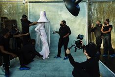 a group of people standing around a woman in a white dress and headdress