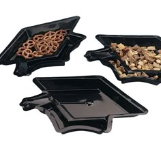 three black trays filled with cereal and pretzels on top of each other