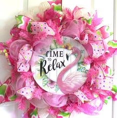 a pink wreath that says time to relax with a flamingo on the front door