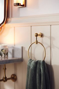 a towel hanging on the wall next to a bathroom sink with a mirror above it