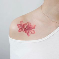 a woman with a pink flower tattoo on her shoulder